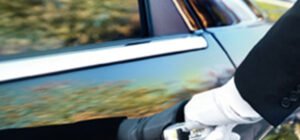 Contact luxury chauffeur service California – professional driver opening car door by LimoVIP USA